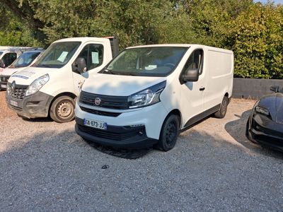 several white vans parked in a parking lot with trees in the background