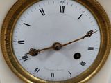 a white clock with roman numerals on the face of it