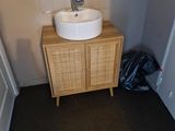 une salle de bains équipée d'un lavabo et d'un meuble de rangement