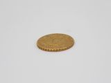 a gold coin sitting on top of a white surface