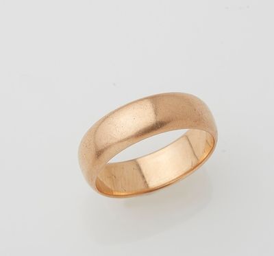 a gold wedding ring on a white background
