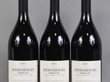 trois bouteilles de vin rouge posées sur une table l'une à côté de l'autre