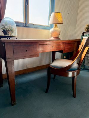 a desk with a lamp and a chair in a room