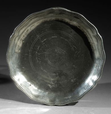 a silver plate sitting on a table with a black background
