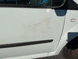 a small white car with a broken door and a broken window