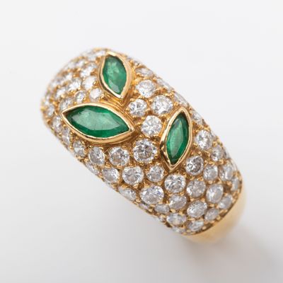 a close up of a gold ring with green and white stones