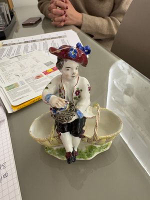 a figurine of a boy sitting in a bowl