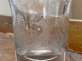a glass cup sitting on a table with a mirror in the background