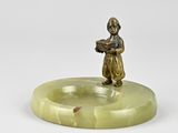 une figurine antique en bronze représentant un garçon tenant un livre