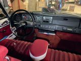 a car dashboard with a steering wheel and a red seat