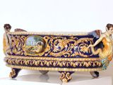 un vase bleu et or sur lequel sont représentés une femme et un homme