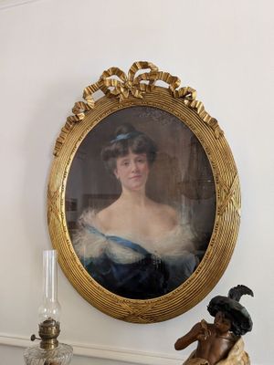 une photo d'une femme en robe bleue posée sur une cheminée