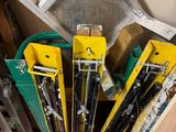 many skis and ski poles stacked on top of each other