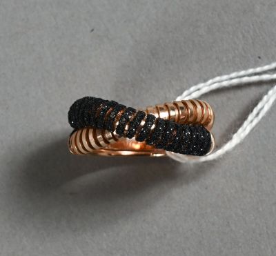 une photo d'une bague noire et dorée suspendue à un cordon