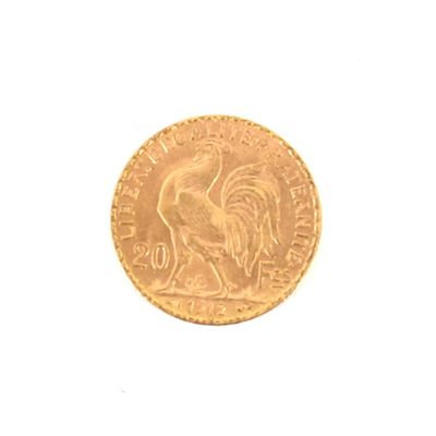 une pièce d'or représentant un coq sur un fond blanc