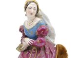 a figurine of a woman sitting on a chair
