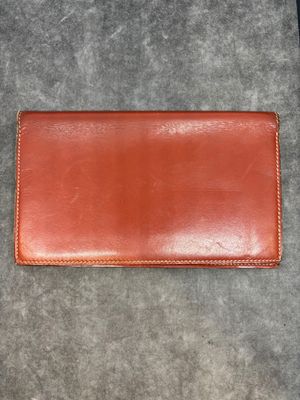a brown leather wallet sitting on top of a gray carpet