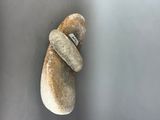 a rock with a ring on it hanging on a wall