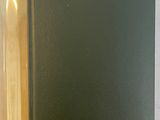 a black book on a white table with a yellow bookmark
