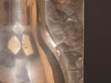 a silver vase sitting on a table with a knife in it