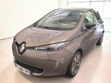 La voiture grise est garée dans une grande pièce dotée de nombreuses fenêtres.