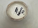 a white vase with writing on it sitting on a table