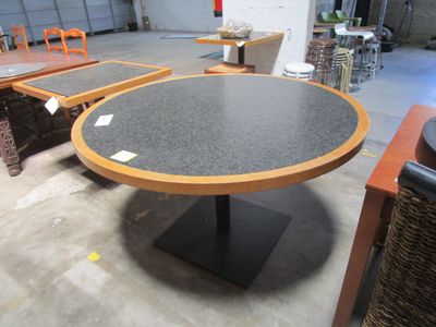 une table dont le plateau est noir et le piètement marron