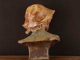 a bust of a woman wearing a hat on a table