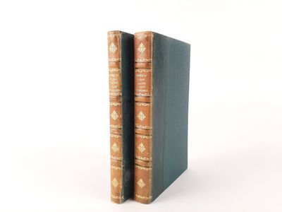 two books are stacked on top of each other on a white surface