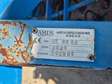 un gros plan d'une pancarte fixée sur le flanc d'un tracteur bleu