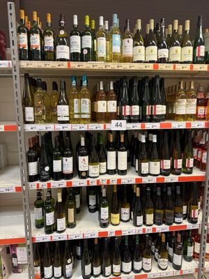 bottles of wine on a shelf in a store for sale