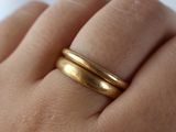 a woman ' s hand with a gold ring on it