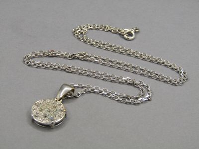 a close up of a necklace with a chain on a table