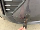 a person holding a ruler in front of a car