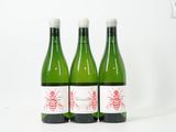 trois bouteilles de vin posées les unes à côté des autres sur une surface blanche