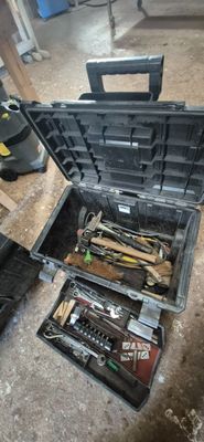 une boîte à outils avec des outils à l'intérieur sur le sol
