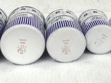several cups are lined up in a row on a white surface