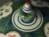 a green vase with a blue and white design on it