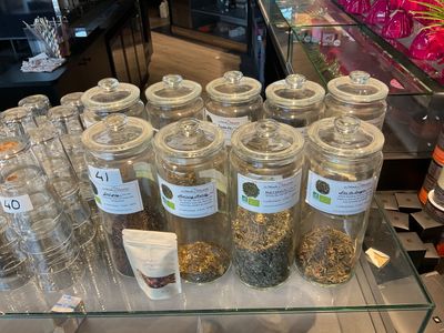 many glass jars filled with different types of tea