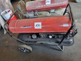 deux réservoirs d'essence rouges posés sur un chariot dans un garage