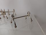 three pairs of silver earrings sitting on a clear surface