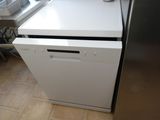 a white dishwasher sitting in a kitchen next to a stove