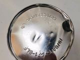 a small silver object on a white surface