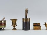 four different types of brass objects on a white surface