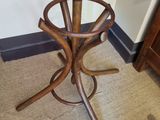 a wooden umbrella stand in the corner of a room
