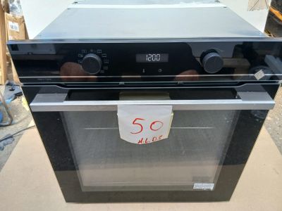 un four noir posé sur une boîte en carton sur laquelle est collée une étiquette de prix