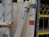 many rolls of white material on the shelves in the store