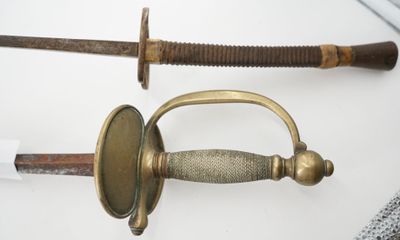 two different types of swords on display on a table