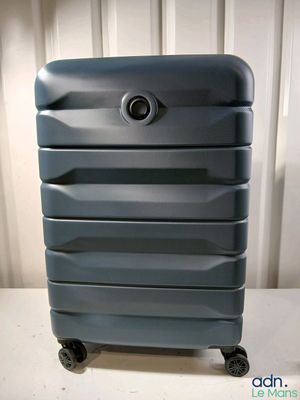 une valise bleue posée sur une table blanche