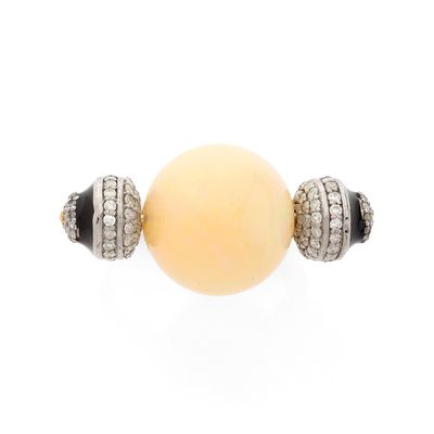 un gros plan sur une perle jaune accompagnée de deux perles noires et blanches